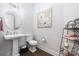 Stylish powder room with pedestal sink, round mirror, and decorative artwork at 234 Pintail Dr, Monroe, NC 28110