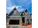 New construction craftsman home featuring attached garage, board and batten siding and covered front entry at 2530 Elkwood Cir, Charlotte, NC 28205