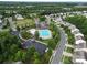 Aerial view of community amenities, including a pool, clubhouse, playground, and parking, surrounded by well-maintained landscaping at 3008 Dundee Ln, Fort Mill, SC 29707