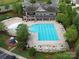 An aerial view of a pristine community pool with ample seating, a playground, and well-kept grounds for summer enjoyment at 3008 Dundee Ln, Fort Mill, SC 29707