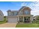 Charming two-story home with stone accents, gray siding, manicured lawn, and inviting front porch at 3008 Dundee Ln, Fort Mill, SC 29707