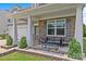 Cozy front porch with seating area, stone accents, columns, and manicured landscaping at 3008 Dundee Ln, Fort Mill, SC 29707