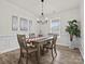 Bright dining room with a wooden table, neutral chairs, modern lighting, and large window at 3038 Lydney Cir, Waxhaw, NC 28173