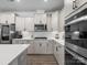 Contemporary kitchen showcases white cabinets, quartz countertops, stainless steel appliances, and wood-style flooring at 3038 Lydney Cir, Waxhaw, NC 28173