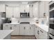 Well-lit kitchen featuring white cabinetry, modern appliances, elegant hardware, and a subway tile backsplash at 3038 Lydney Cir, Waxhaw, NC 28173
