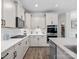 Bright kitchen with white cabinets, stainless steel appliances, tile backsplash, built-in oven, and pantry access at 3038 Lydney Cir, Waxhaw, NC 28173