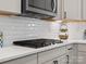 Close up of cooktop in modern kitchen with white cabinets and stainless steel appliances at 3038 Lydney Cir, Waxhaw, NC 28173