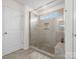 Shower with glass door, tan tile, niche, shower head, and window at 3038 Lydney Cir, Waxhaw, NC 28173