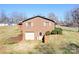 Rear exterior of a brick home with a garage, showcasing a functional design and a well-maintained landscape at 3087 E Nc Hwy 150 Hwy, Lincolnton, NC 28092