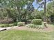 Well-manicured backyard with lush landscaping, including mature trees, shrubs, and a stone bird bath at 3600 Carmel Rd, Charlotte, NC 28226