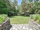 Expansive backyard featuring lush greenery, stone steps and retaining walls, perfect for outdoor enjoyment at 3600 Carmel Rd, Charlotte, NC 28226
