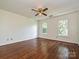Well-lit bedroom features lustrous hardwood floors and a modern ceiling fan at 3600 Carmel Rd, Charlotte, NC 28226