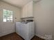 Well-lit laundry room features a white washer and dryer set and white storage cabinets at 3600 Carmel Rd, Charlotte, NC 28226