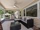 Cozy screened porch with outdoor furniture, ceiling fan, and brick floors at 3600 Carmel Rd, Charlotte, NC 28226