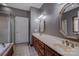 Bathroom with dual vanity sinks and mirrors, featuring natural wood cabinets and trim at 369 Falcon Dr, Concord, NC 28025