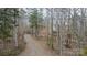 View of long gravel driveway leading to a charming home nestled in a wooded setting at 369 Falcon Dr, Concord, NC 28025