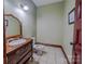 Powder room with wooden vanity, classic mirror, and tile flooring at 369 Falcon Dr, Concord, NC 28025