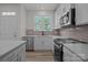 Bright kitchen features modern white cabinets, stainless steel appliances, and beautiful wooden floors at 4109 Walking Ridge Rd # 57, Charlotte, NC 28208