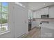 Bright kitchen features modern white cabinets, stainless steel appliances, and beautiful wooden floors at 4109 Walking Ridge Rd # 57, Charlotte, NC 28208