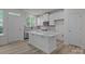 Bright kitchen features modern white cabinets, stainless steel appliances, island and wooden floors at 4109 Walking Ridge Rd # 57, Charlotte, NC 28208