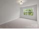 Sunlit bedroom featuring neutral carpet and a window with views of lush green trees and natural light at 4113 Walking Ridge Rd # 56, Charlotte, NC 28208