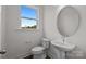 Modern half-bath with a vessel sink, pedestal, round mirror, and wood-look flooring at 4117 Walking Ridge Rd # 55, Charlotte, NC 28208
