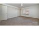Bright bedroom features carpet floors, a ceiling fan, and closet storage at 457 Birchwood Ne Trl, Concord, NC 28025