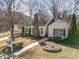 Inviting single-story home with a brick chimney, red shutters, landscaped yard, and detached garage at 457 Birchwood Ne Trl, Concord, NC 28025