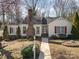 Charming single-story home features a brick chimney, red shutters, and a well-maintained front yard at 457 Birchwood Ne Trl, Concord, NC 28025