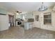 Cozy kitchen featuring light blue cabinets, breakfast bar seating, and tiled floors, leading to a sunroom at 457 Birchwood Ne Trl, Concord, NC 28025