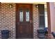 Elegant wooden front door with decorative glass panels, framed by brick and sconce lighting at 4866 E Nc Hwy 150 Hwy, Lincolnton, NC 28092