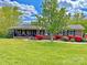 Charming brick home with a lush green lawn, vibrant landscaping, and a welcoming front porch at 4866 E Nc Hwy 150 Hwy, Lincolnton, NC 28092