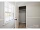 Walk-in bedroom closet with wire shelving, neutral carpet, and a bright window at 6322 Old Pineville Rd # E, Charlotte, NC 28217