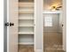 Bedroom closet with custom shelving, neutral carpet, and view into bright bedroom at 6322 Old Pineville Rd # E, Charlotte, NC 28217