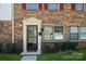 Charming brick townhome with red shutters, well-maintained landscaping, and inviting front entrance at 6322 Old Pineville Rd # E, Charlotte, NC 28217
