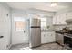 Well-lit kitchen featuring stainless steel appliances, white cabinets, granite countertops, and tiled backsplash at 6322 Old Pineville Rd # E, Charlotte, NC 28217