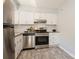Modern kitchen featuring stainless steel appliances, white cabinets, and stylish flooring at 6322 Old Pineville Rd # E, Charlotte, NC 28217
