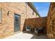 Private patio with brick wall, outdoor seating, and rear entrance under a sunny blue sky at 6322 Old Pineville Rd # E, Charlotte, NC 28217
