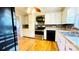 Well-lit kitchen with stainless steel appliances, mosaic backsplash, wood floors, and white cabinetry at 742 Aquadale Rd, Albemarle, NC 28001