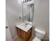 Bathroom featuring a wood vanity, mirror, sink, and toilet, with neutral wall color at 8353 Ainsworth St, Charlotte, NC 28216