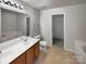 Bathroom featuring a double sink vanity, soaking tub, and linen closet at 8353 Ainsworth St, Charlotte, NC 28216