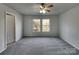 Large bedroom with a ceiling fan, carpet floors, and natural light at 8353 Ainsworth St, Charlotte, NC 28216