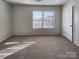 Carpeted bedroom with a large window and neutral walls, offering a cozy atmosphere at 8353 Ainsworth St, Charlotte, NC 28216