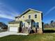 Two story home with a green exterior, stone accents, two car garage, and front porch at 1022 Heath Helms Rd, Monroe, NC 28110