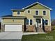 Two story home with a green exterior, stone accents, two car garage, and front porch at 1022 Heath Helms Rd, Monroe, NC 28110
