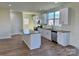 Bright kitchen with white cabinets, an island, stainless steel appliances, and hardwood floors at 1022 Heath Helms Rd, Monroe, NC 28110