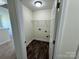 Compact laundry room featuring wood flooring, a wire shelf, and washing machine hookups at 1022 Heath Helms Rd, Monroe, NC 28110