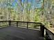 A wooden deck looks out onto a wooded backyard at 10550 Worsley Ln, Charlotte, NC 28269