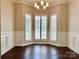 Dining room featuring hardwood floors, stylish lighting, and a bay window with white shutters at 10550 Worsley Ln, Charlotte, NC 28269