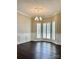 Dining room featuring hardwood floors, crown molding, stylish lighting, and a bay window with white shutters at 10550 Worsley Ln, Charlotte, NC 28269